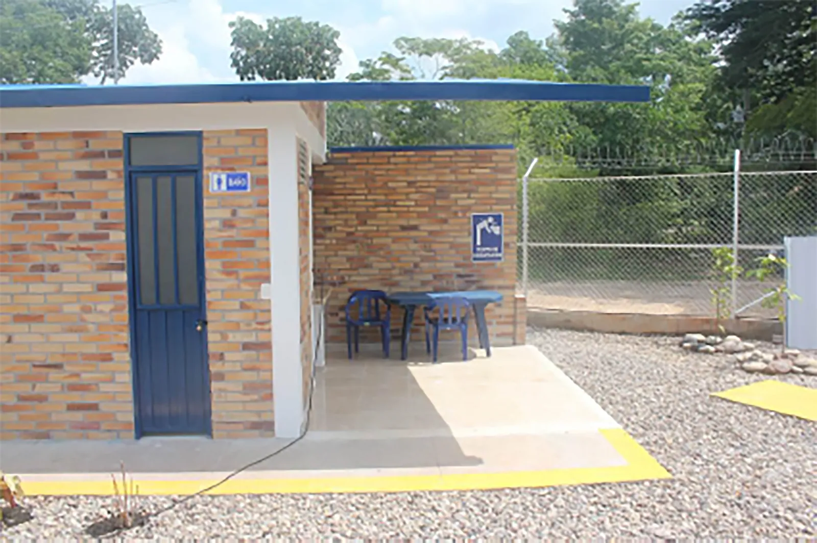 Acceso exterior a los baños junto al cerramiento perimetral con concertina