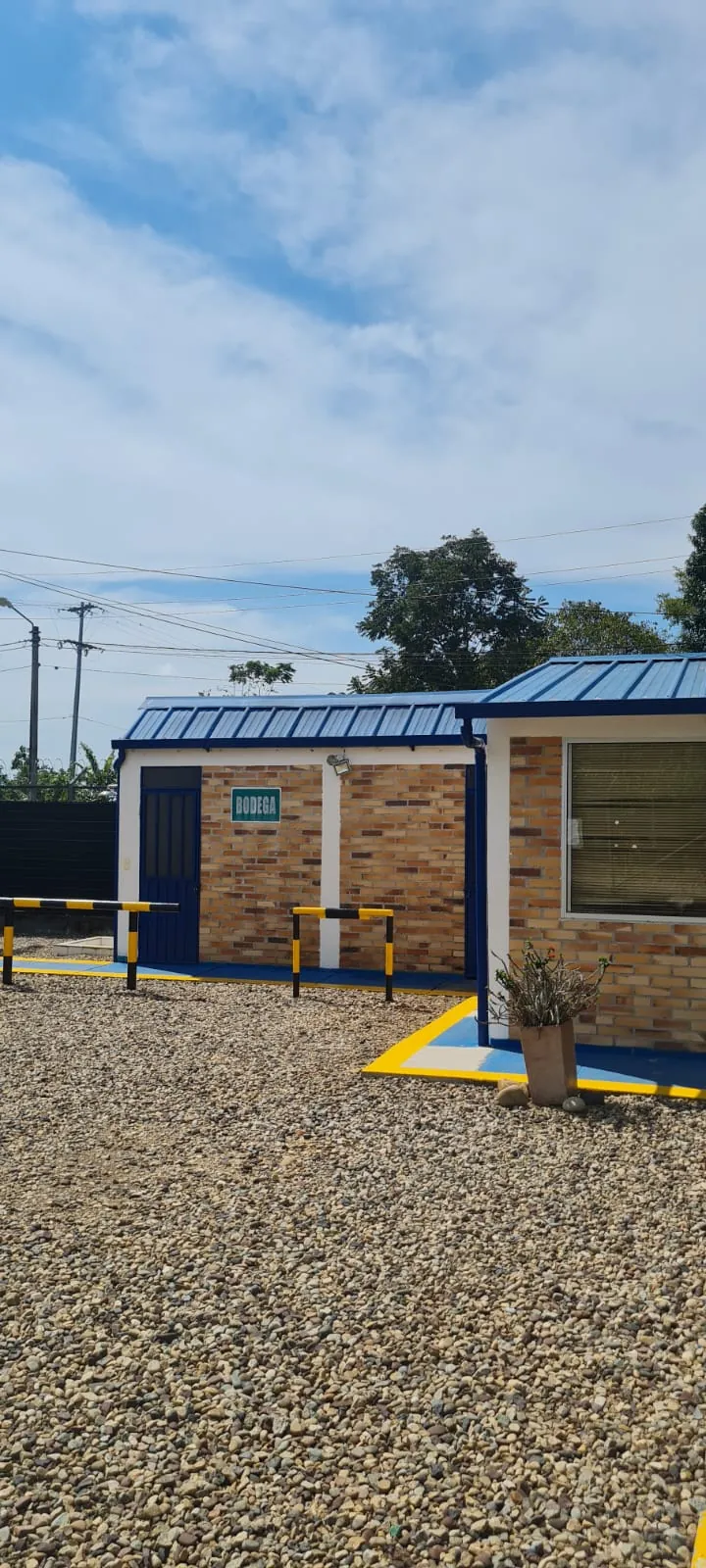 Bodega auxiliar con puerta metálica y demarcación de seguridad en el patio