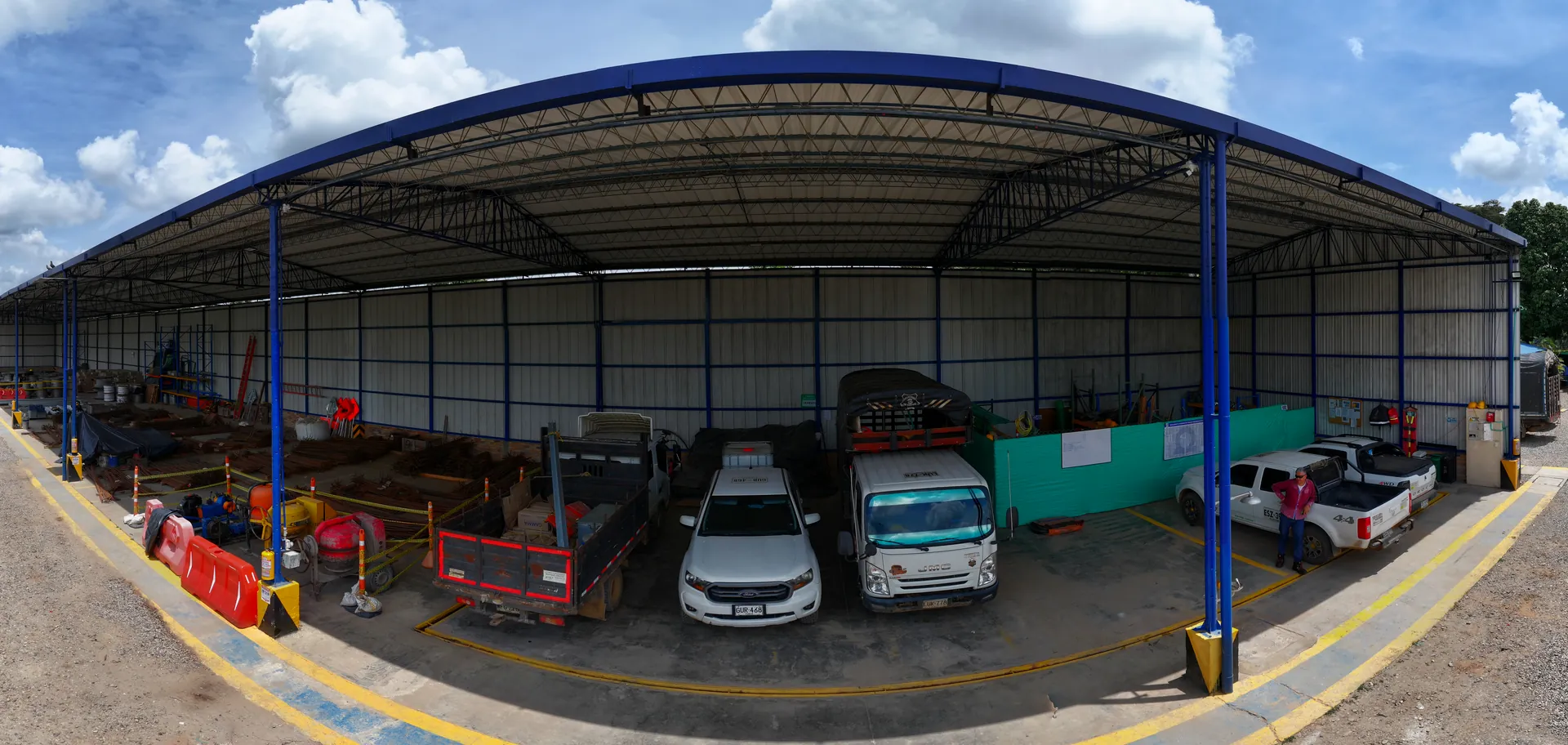 Vista panorámica del frente del hangar con vehículos y equipos bajo cubierta